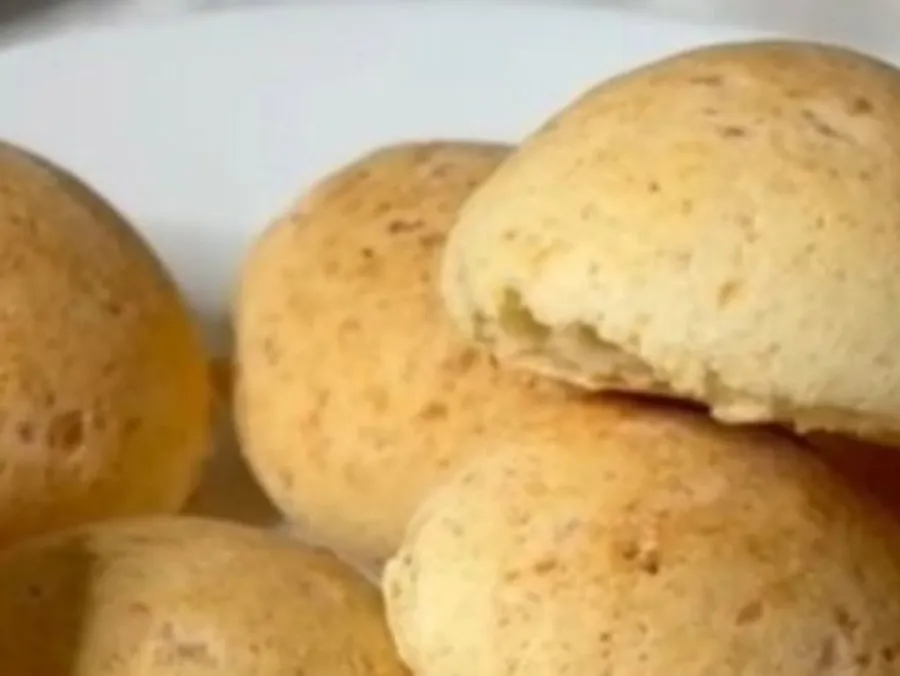Des pandebonos dorés empilés sur une assiette blanche